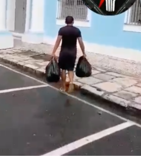 Homem deixa sacolas de lixo em frente a prefeitura